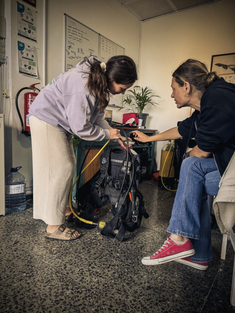 Learning scuba diving equipment setup during Open Water Diver course.