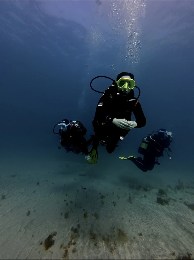 Diver descending into crystal clear waters off Los Cristianos, Tenerife with Barbarian Diving"
