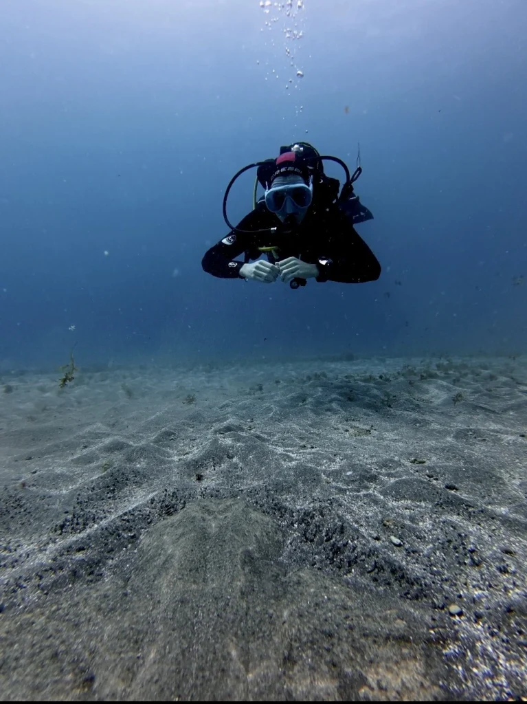 Diver demonstrating perfect buoyancy control over volcanic reef in Los Cristianos"