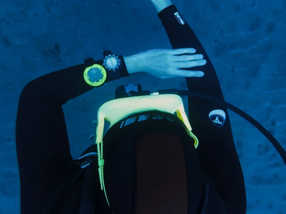 Scuba diver using a compass and hand signals for underwater navigation during the SSI Navigation adventure dive at Barbarian Diving Tenerife