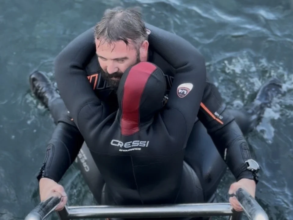 SSI Rescue Diver student practising diver extraction from the water up a ladder during confined water training at Barbarian Diving Tenerife